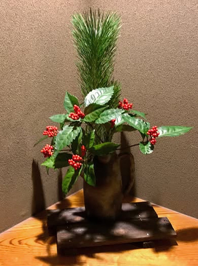 和風の背景に飾られた松と千両の花瓶